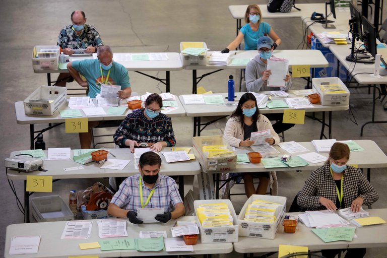 Los trabajadores electorales clasifican algunas de las miles de boletas por correo en el Registro de Votantes del Condado de Orange en Santa Ana, California. Foto: Infobae.