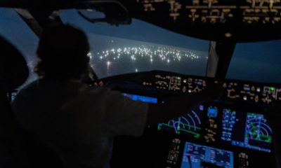 Imagen desde la cabina del Boeing 787de Enrique Piñeyro, comandado por él mismo (de espaldas en la foto). Lo que se ve a través del vidrio es la ciudad de pesqueros extranjeros. (Foto: Franco Fafasuli)