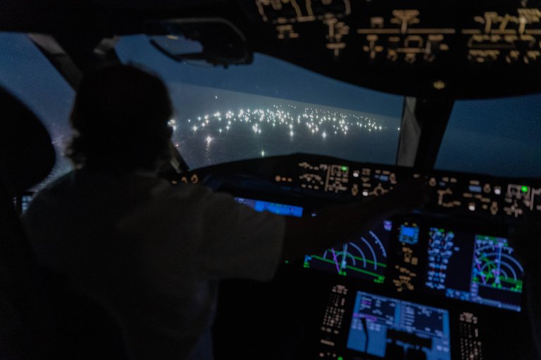 Imagen desde la cabina del Boeing 787de Enrique Piñeyro, comandado por él mismo (de espaldas en la foto). Lo que se ve a través del vidrio es la ciudad de pesqueros extranjeros. (Foto: Franco Fafasuli)