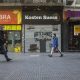 Personas caminan frente a locales comerciales cerrados de forma definitiva en la calle Florida, en la ciudad de Buenos Aires. Foto: La Jornada.