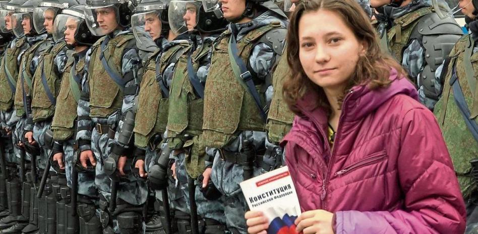 Olga Mísik posa con una copia de la Constitución rusa frente a policías antidisturbios en una manifestación en Moscú en el 2019. Foto: AFP.