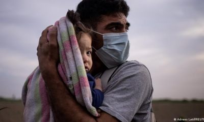 Una criatura de pecho es abrazada por su padre, un desplazado en el hemisferio. Foto: DW.