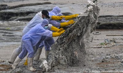 Marinos, durante las labores de limpieza de una de las playas contaminadas. Foto: Dw.