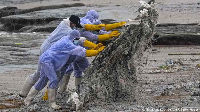 Marinos, durante las labores de limpieza de una de las playas contaminadas. Foto: Dw.