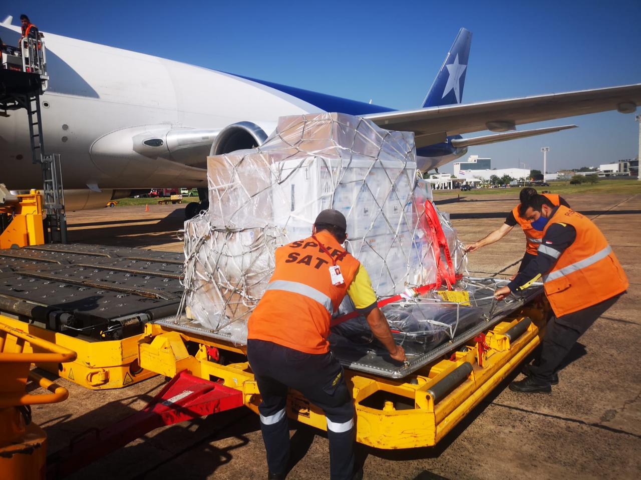 Momento de la descarga del lote de vacunas. Atrás el avión que se encargó del traslado. (Foto Presidencia).