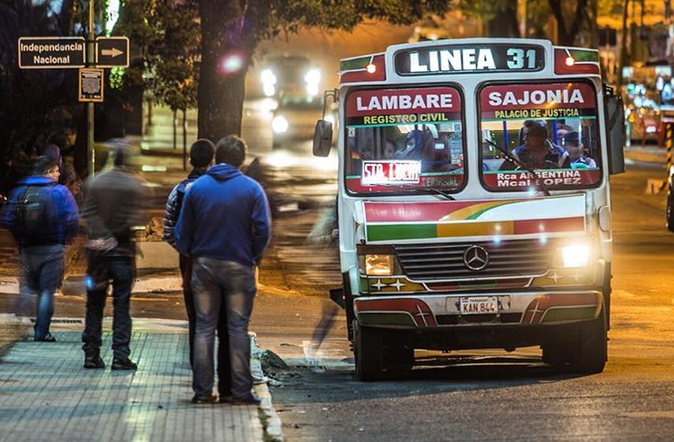 Pasajeros de noche esperando el ómnibus. Imagen de archivo.