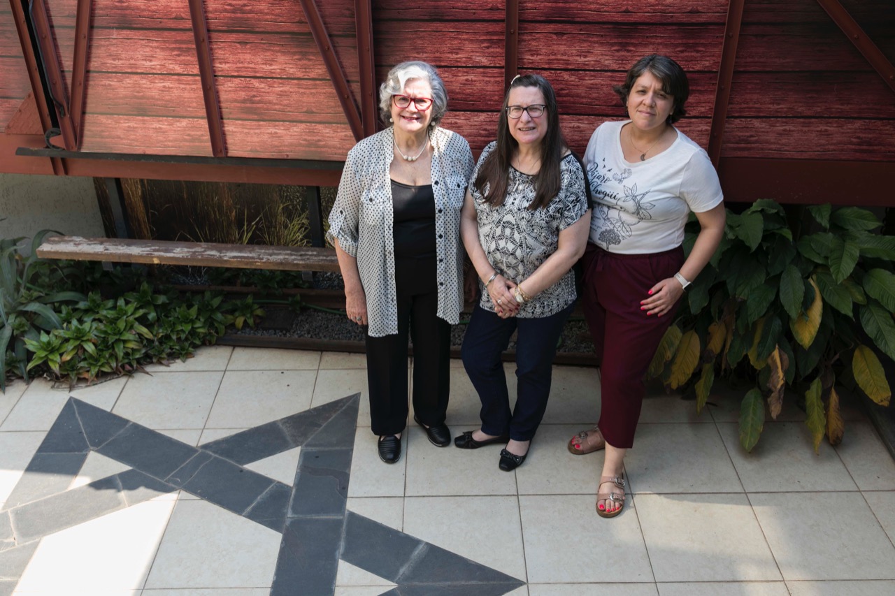 Ruth Kohan, Mónica Strupp-Schvartzman y Romina Burgos Mancini junto a la imagen que evoca los trenes del Holocausto © Laura Mandelik