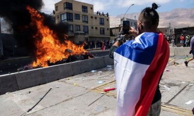 Un ciudadano toma una imagen de la quema de ropa y pertenencias de los migrantes que han llegado a Iquique en los últimos meses. Foto: Getty.