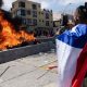 Un ciudadano toma una imagen de la quema de ropa y pertenencias de los migrantes que han llegado a Iquique en los últimos meses. Foto: Getty.