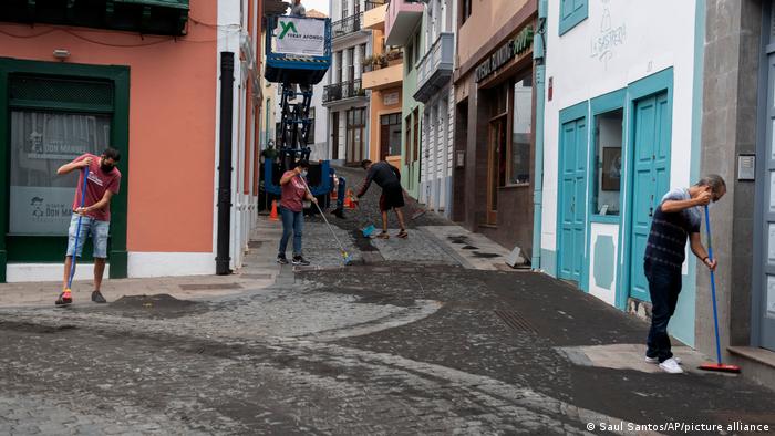 Vecinos limpian las cenizas en las calles de Santa Cruz de La Palma, este 27 de septiembre de 2021. Foto: Picture Aliance.