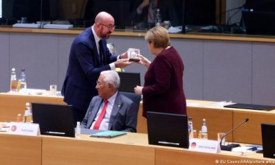 El presidente del Consejo Europeo, Charles Michel, le da una placa de agradecimiento a Merkel. Foto: Picture Aliance.