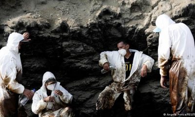 Operarios de limpieza descasan en Ventanilla durante las labores de retirada del crudo el pasado miércoles.