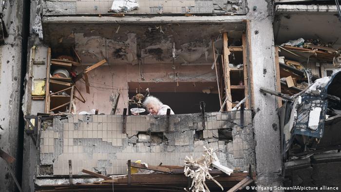 Esta mujer de la tercera edad revisa los despojos dejados tras el probable derribo de un avión que cayó sobre un edificio de residentes civiles Foto: Picture Aliance.