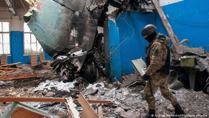 Un militar ucraniano pasa junto a los restos de un avión ruso de combate Su-34 que fue derribado en Kharkiv, Ucrania. Foto: Picture Aliance.