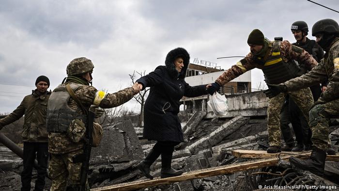 Soldados voluntarios ucranianos ayudan a la población civil a evacuar Irpín. Foto: Infobae.