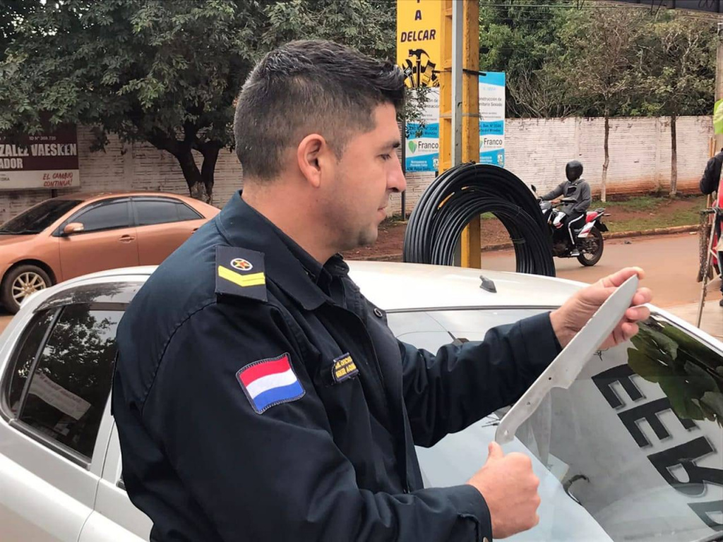 El oficial interviniente muestra el arma incautada de la mochila del menor. Foto: Radio Concierto