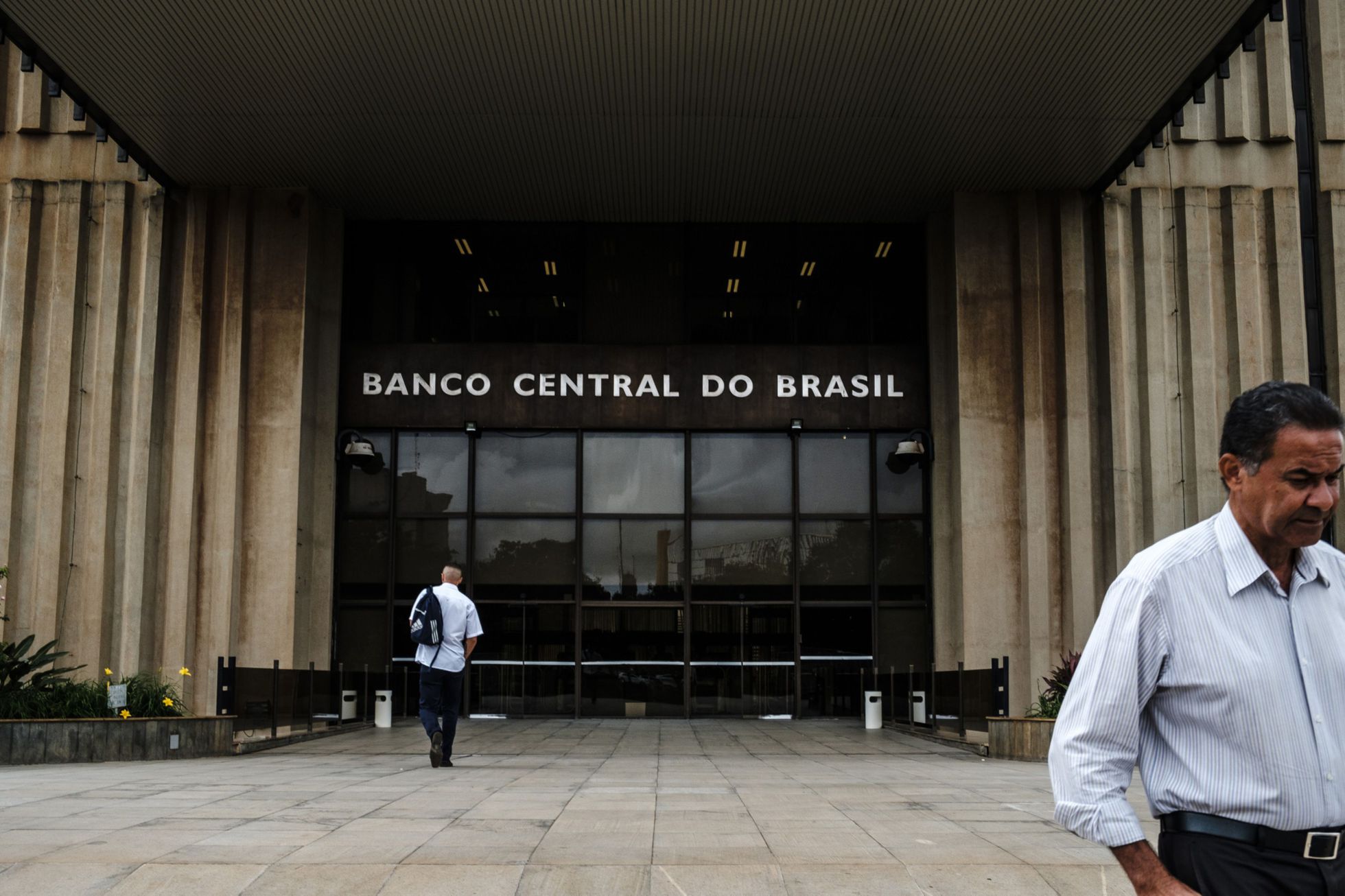 Peatones pasan frente a la sede del Banco Central de Brasil, en Brasilia. Foto: El País.