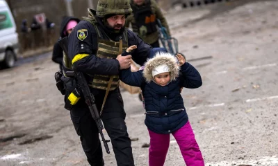 Una niña separada de sus padres es rescatada por un soldado ucraniano durante un bombardeo ruso. Foto: Infobae