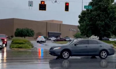 Un automóvil pasa frente a la presencia policial fuera del Greenwood Park Mall en Greenwood. Foto: Infobae