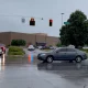 Un automóvil pasa frente a la presencia policial fuera del Greenwood Park Mall en Greenwood. Foto: Infobae