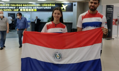 Helen Montiel junto a Rubén Zacarías posan con la bandera tricolor, momentos antes de abordar el vuelo que los lleve finalmente hasta la India. Gentileza