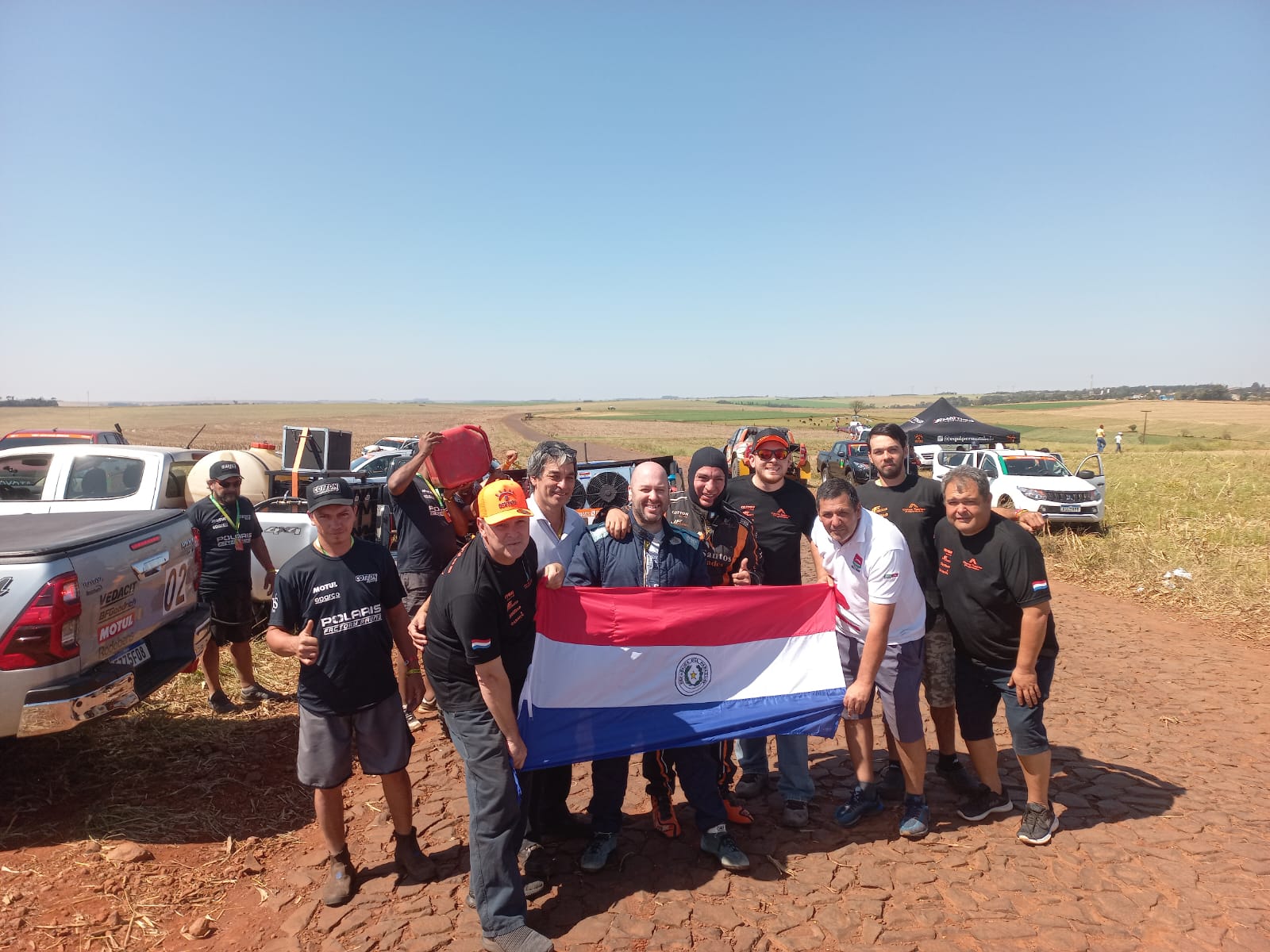 La tripulación paraguayo-argentino posa junto a los aficionados compatriotas al final de la primera etapa sabatina. Foto: Gentileza