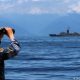 Un soldado chino observa los ejercicios militares de su país mientras, al fondo, una fragata taiwanesa monitorea la situación. Foto: DW