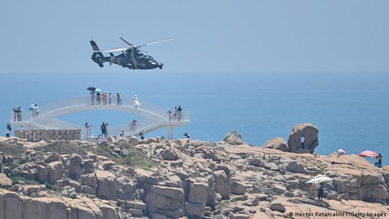 Un helicóptero de la fuerza aérea china despega hacia operaciones militares desde la isla de Pingtan, la más cercana a Taiwán ante la mirada de turistas. Foto: DW