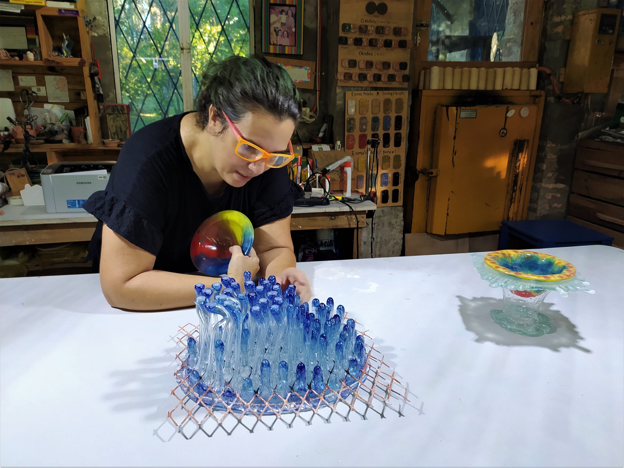 Laura Giucich y su escultura "Ykua", creada con la técnica de vidrio fluido. Cortesía