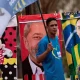 Un hombre con una bandera rodeado de toallas con las imágenes de Lula y Bolsonaro, Foto: Infobae,