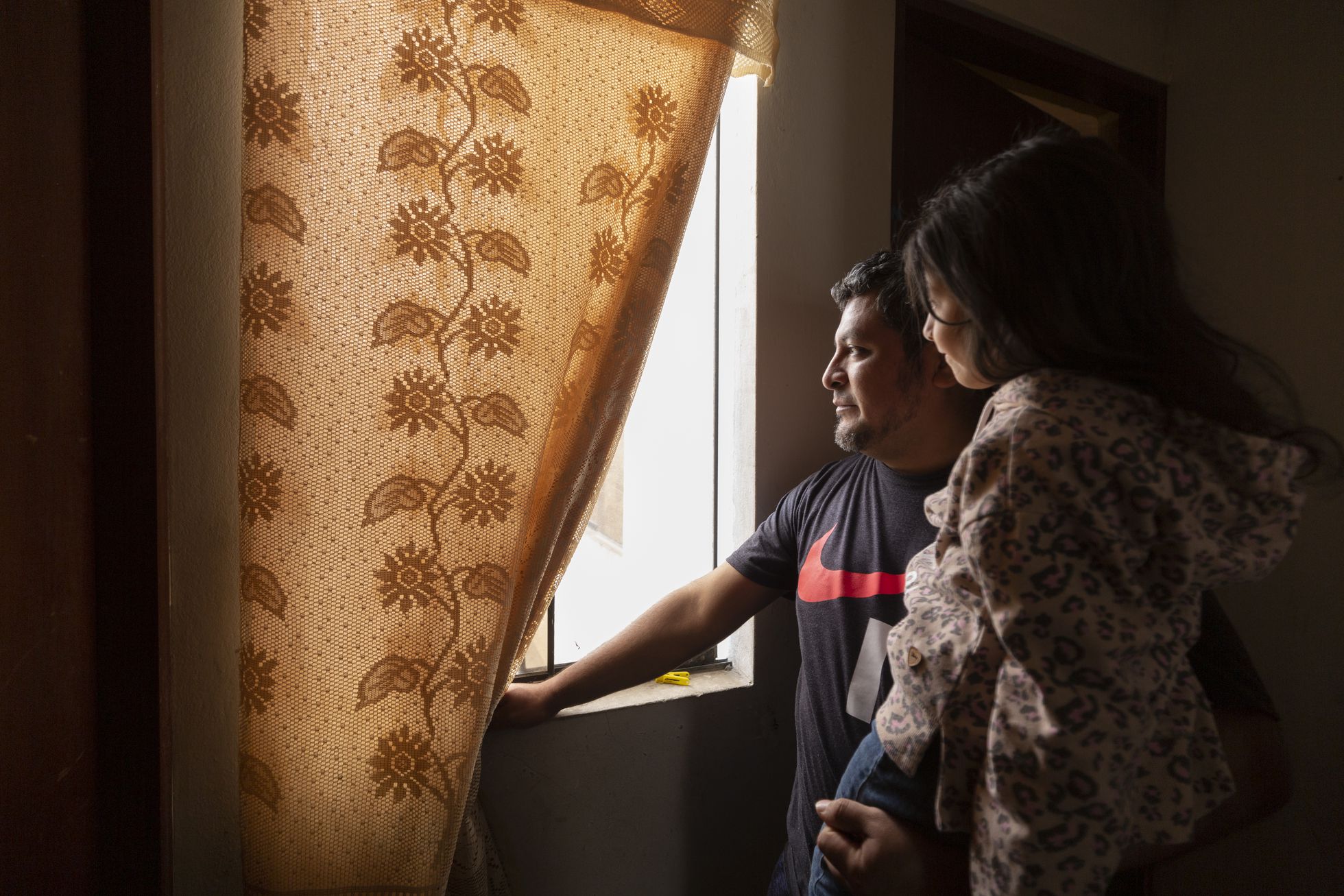 Jonathan carga a su hija en el departamento que alquilan en el distrito de Villa El Salvador, en Lima (Perú), el 1 de octubre de 2022. Foto: El País