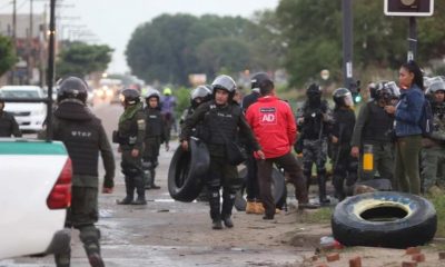 Policías antimotines de Bolivia retiran unos neumáticos que eran usados para bloquear calles hoy, en Santa Cruz (Bolivia). Foto: Infobae