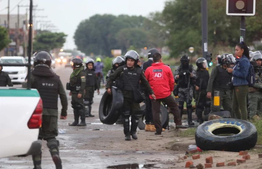 Policías antimotines de Bolivia retiran unos neumáticos que eran usados para bloquear calles hoy, en Santa Cruz (Bolivia). Foto: Infobae