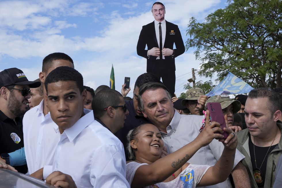 El presidente Bolsonaro posa con una admiradora para una retrato este lunes en el asentamiento de trabajadores rurales Nueva Jerusalén, en Brasilia. Foto: El País