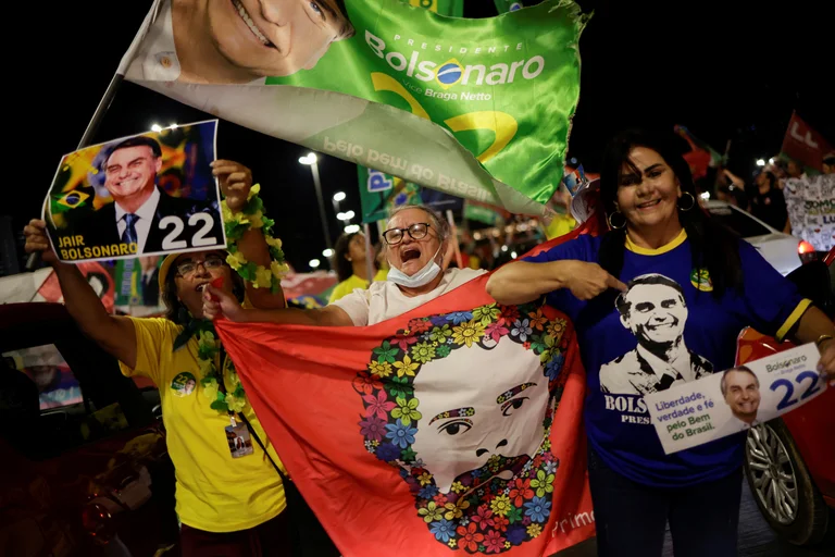 Partidarios del presidente de Brasil y candidato a la reelección Jair Bolsonaro y partidarios del ex presidente de Brasil Luiz Inacio Lula da Silva hacen campaña juntos en una calle durante una campaña electoral en Brasilia. Foto: Infobae