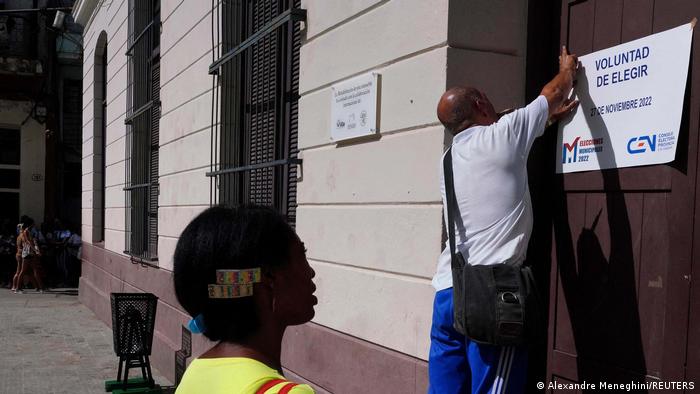 Un hombre cuelga un aviso convocando a las elecciones municipales en La Habana. Foto: DW