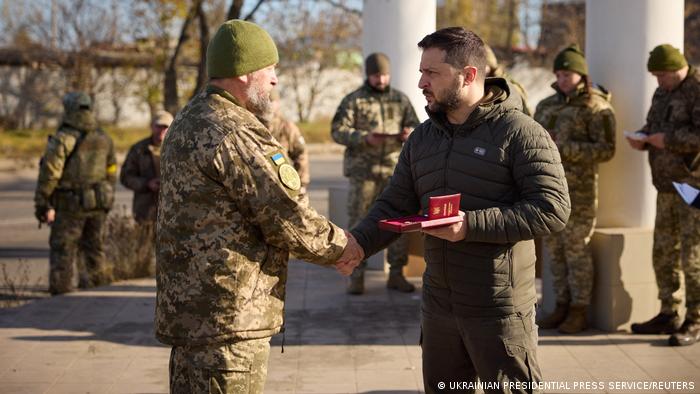 El presidente ucraniano, Volodimir Zelenski, saluda a un miembro de su Ejército en Jersón. Foto: DW.