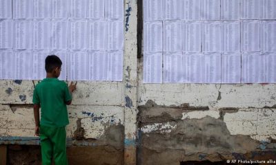 Un niño mira las listas del censo electoral pegadas en un muro ayer en Managua. Foto: DW.