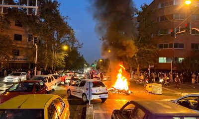 Una moto de la policía ardía durante una protesta por la muerte de la joven Mahsa Amini, el 19 de septiembre en Teherán. Foto: El País.