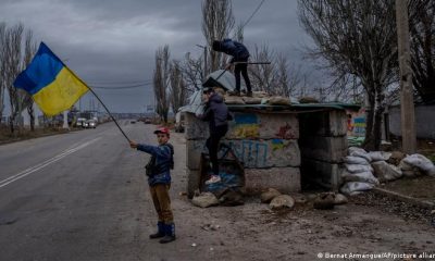 Niños ucranianos juegan en un puesto de control abandonado en Jersón, sur de Ucrania. Foto: DW
