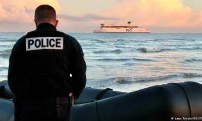 Un policía francés junto a embarcación, que mingrantes querían usar para abandonar la cosfa francesa hacia Inglaterra. Foto: DW