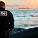 Un policía francés junto a embarcación, que mingrantes querían usar para abandonar la cosfa francesa hacia Inglaterra. Foto: DW