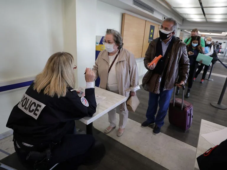 Una agente de la policía fronteriza francesa controla a los pasajeros a su llegada al aeropuerto de Niza en medio del brote de la enfermedad por coronavirus. Foto: Infobae