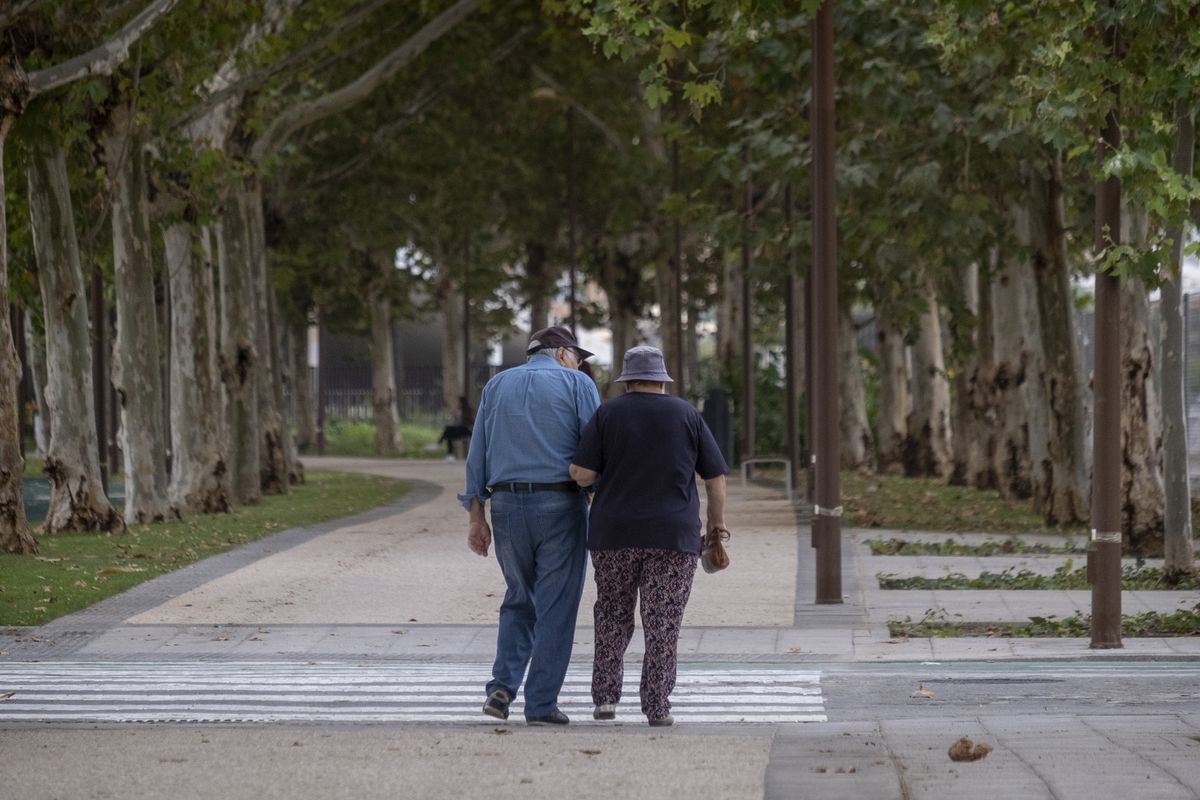 Una pareja de ancianos camina por la calle agarrada del brazo. Foto: El País