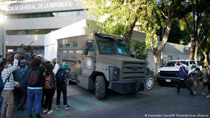 Periodistas toman fotos a un transporte blindado que sale del edificio de la fiscalía donde fue llevado Ovidio Guzmán, uno de los hijos del ex jefe del cártel de Sinaloa, Joaquín "El Chapo" Guzmán, detenido el jueves 5 de enero de 2023. Foto: DW