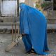 Los talibanes prohibieron a las mujeres practicar deportes. En esta foto, una mujer afgana con burka sostiene un bate de cricket. Foto: DW