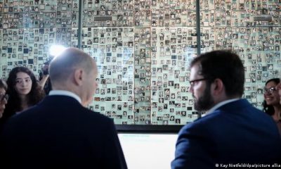 El canciller de Alemania, Olaf Scholz, y el presidente de Chile, Gabriel Boric, observan imágenes de víctimas de la dictadura durante su visita al Museo de la Memoria. Foto: DW