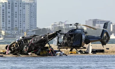 Dos helicópteros cobrados se sientan en la arena en una escena de colisión cerca de Seaworld, en Gold Coast, Australia, el lunes 2 de enero de 2023. Foto: Infobae