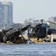 Dos helicópteros cobrados se sientan en la arena en una escena de colisión cerca de Seaworld, en Gold Coast, Australia, el lunes 2 de enero de 2023. Foto: Infobae