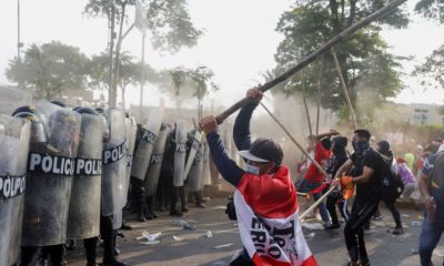 Manifestantes se enfrentan a la policía durante la marcha de este jueves, en Lima. Foto: El País